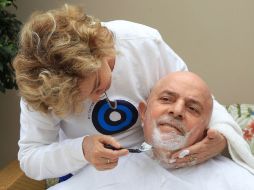 Marisa Leticia afeita el rostro del exgobernante mientras luce un suéter con campaña contra el cáncer de mama. AP  /