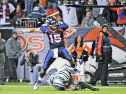 El mariscal de los Broncos, Tim Tebow, salta sobre un defensivo de los Jets, para enfilarse a anotar el touchdown de la victoria. AP  /