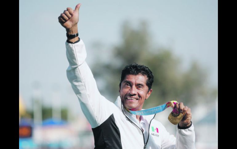 arón Gordián presume su presea dorada que ganó en los mil 500 metros T54, en la cual México hizo el uno, dos y tres. EFE  /