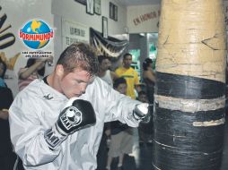 Saúl Álvarez golpea el costal, en el marco de su entrenamiento público. ESPECIAL  /