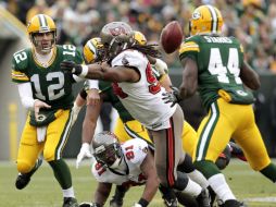 Aaron Rodgers (12) lanza la pelota a James Starks (44) tras ser presionado por Adrian Clayborn (C) de Tampa Bay. AP  /