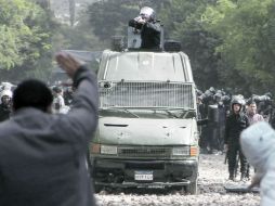 Un manifestante alza las manos, luego de que un Policía le apunta con un rifle durante las manifestaciones de El Cairo. REUTERS  /