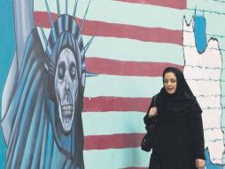 Una mujer iraní camina delante de un mural anti Estados Unidos, pintado en la pared de la embajada estadounidense en Teherán. AFP  /