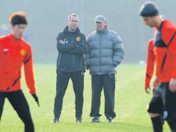 El técnico del Manchester United, Alex Ferguson (der.) observa la práctica de su equipo, previo al cotejo ante el Benfica. AFP  /
