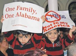 Dos niños sostienen carteles en contra de la ley antiinmigrante de Alabama. EFE  /