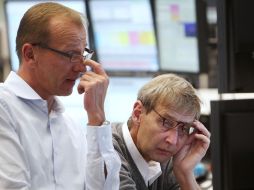 Trabajadores de la bolsa alemana observan el movimiento de las acciones en sus pantallas. AP  /