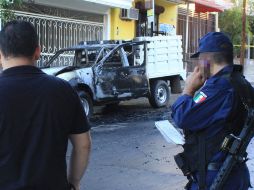 Autoridades vigilan el lugar en donde fue hallado uno de los dos vehículos que tenían cuerpos calcinados en su interior. EFE  /