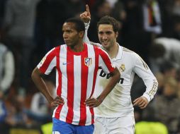 Gonzalo Higuain del Real Madrid celebra su gol junto a Paulo Assuncao del Atlético de Madrid. AP  /