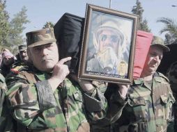 Soldados sirios portan el féretro de uno de los 17 militares muertos en una emboscada montada por los rebeldes. EFE  /