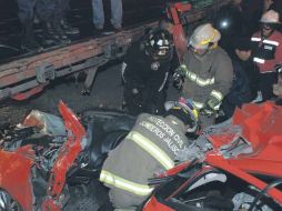 Rescatistas trabajan en el vehículo que se impactó contra la caja de un tráiler, en la vía que va de Ciudad Guzmán hacia Zapotiltic.  /