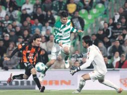 Oribe Peralta (centro) dispara ante la salida del portero Édgar Hernández (der.) y la marca de Gerardo Espinoza. MEXSPORT  /