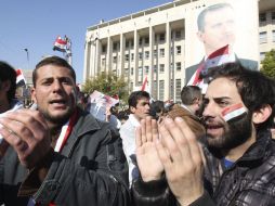Manifestantes sirios gritan consignas ante una fotografía gigante del presidente Bashar Assad, en apoyo a su régimen. EFE  /