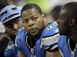 Ndamukong Suh (centro) recibe un fuerte castigo de la NFL. AP  /