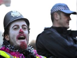 Un manifestante disfrazado de policía grita junto a un agente de policía durante la manifestación de funcionarios. EFE  /