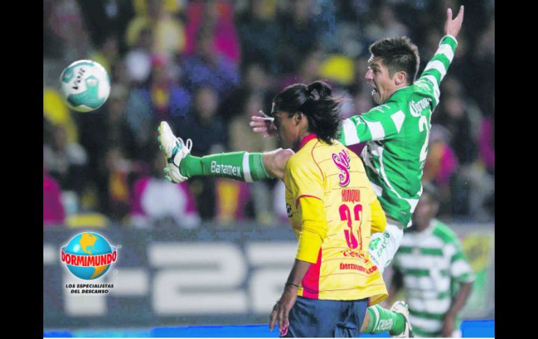 El delantero lagunero, Oribe Peralta, salta para disparar, ante la marca del defensa de Monarcas, Joel Huiqui. MEXSPORT  /