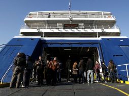 Huelguistas vigilan la entrada de un barco parado en el puerto griego de Piraeus durante la manifestación. EFE  /