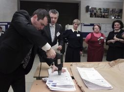 Miembros de una mesa electoral destuyen las papeletas tras finalizar el recuento. EFE  /