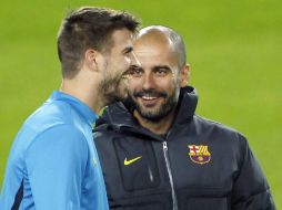 El defensa Gerard Piqué (I) y el entrenador 'Pep' Guardiola charlan durante un entrenamiento. EFE  /