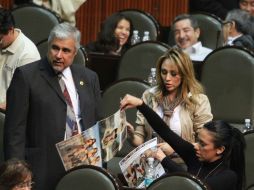 Una de las azafatas muestra el calendario a legisladores. NTX  /