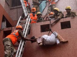 Una sobreviviente de la deflagración es puesta a salvo mediante cuerdas que maniobran los rescatistas. AFP  /