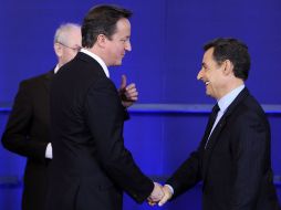 David Cameron y Nicolás Sarkozy se saludaron antes de votar sobre el tratado de la UE. EFE  /