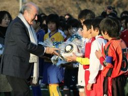 Niños japoneses recibe balones de futbol de manos del presidente de la FIFA, Joseph Blatter. AFP  /