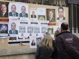 Sirios miran carteles electorales de los candidatos durante la jornada de elecciones de los Consejos Municipales. EFE  /