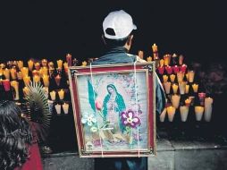 Devotos de la Virgen Morena colocan veladoras en la Basílica de Guadalupe, en la capital del país.  /