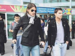 El defensa Leandro Cufré (der.) sale del aeropuerto.  /