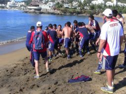 Armando Camacho es cargado por algunos elementos de Chivas, quienes lo aventaron al mar.  /