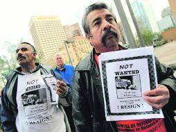 Los manifestantes Sergio Juárez (der.), y Rafael Guerrero, esperan entrar a la Junta de Supervisores del Condado de Maricopa. AP  /