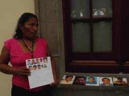 En la imagen, una víctima muestra las fotos de sus desaparecidos. ARCHIVO  /