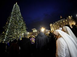 Unas religosas miran el árbol de Navidad del Vaticano que se encendió esta noche. AFP  /