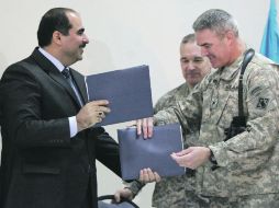 Hussein al Assadi, autoridad iraquí, y el coronel estadounidense Richard Kaiser, realizan el cambio de “manos” de una base militar. AFP  /
