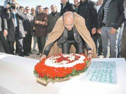 Moncef Marzouki coloca flores en la tumba del tunecino que dio origen a las manifestaciones de la “Primavera Árabe”. AP  /