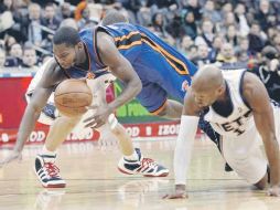El guardia de los Knicks Toney Douglas (azul) disputa la pelota con el jugador de los Nets Sundiata Gaines. AP  /