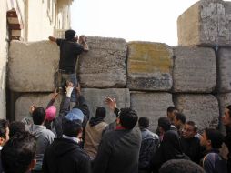 Un hombre intentaba trepar uno de los muros que separa una sede gubernamental en El Cairo. AP  /