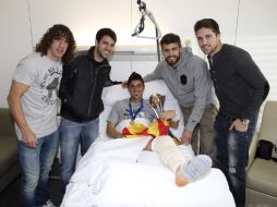 Villa sostiene el trofeo que le han ofrecido sus compañeros Carles Puyol, Cesc Fàbregas, Gerard Piqué y Andreu Fontás. EFE  /