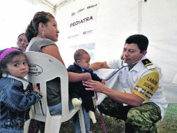 Vecinos de San Fernando asisten a una consulta en pediatría. Los soldados también hicieron cortes de pelo y pintaron fachadas. EFE  /
