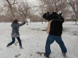 Dos personas juegan en la nieve que cubre Ciudad Juárez. La nieve y temperaturas bajo cero son una rareza en esta zona. AFP  /