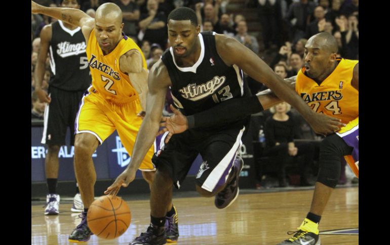 El guardia de los Kings de Sacramento, Tyreke Evans (c), persigue a la pelota entre Derek Fisher (i) y Kobe Bryant de los Lakers. AP  /
