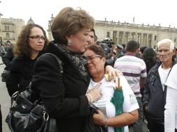 Consuelo  Perdomo(C),  abraza a Oliva Olarte, madre de Jorge  Trujillo, tras ir a una ceremonia para los cuatro rehenes ejecutados. AP  /