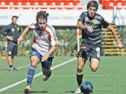 Omar Arellano, de Chivas, trata de alcanzar al mediocampista de Leones, César Evaristo, durante el partido de ayer. MEXSPORT  /