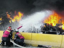 Bombero intentan apagar el incendio causado al volcarse cisterna con 36 mil litros de gasolina. REUTERS  /