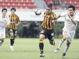 El atacante de Leones Negros Renato Rivera disputa el esférico con un defensor coreano.  /