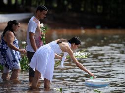 Vestidos de blanco y arrojando al mar flores blancas, los fieles de Yemanjá le rinden tributo en Copacabana. AFP  /