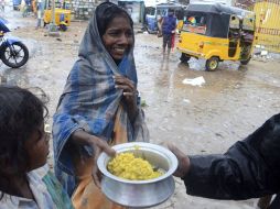 Una mujer recibe un plato de comida proporcionada por el gobierno de Tamil Nadu como ayuda a los damnificados. EFE  /