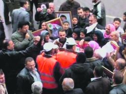 Imagen proporcionada por un canal de televisión sirio en el que se ve a los observadores de chaleco naranja hablando con mujeres sirias  /