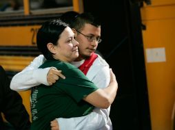Jennifer Dávila (I), abraza fuertemente a su hijo Jordan tras ser avisada del tiroteo que se efectuó en el lugar. AP  /