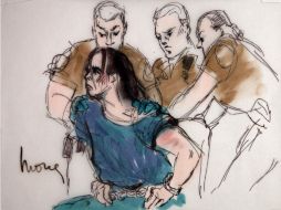 Harry Burkhart,de Alemania, es restringido por los guardias cuando trata de pararse y sentarse durante su comparecencia. AP  /